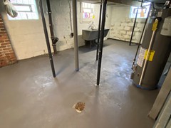 After repairs, the team resurfaced the entire basement floor using a skim coat to provide a neat, fresh finish and an extra layer of protection