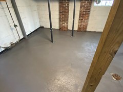 After repairs, the team resurfaced the entire basement floor using a skim coat to provide a neat, fresh finish and an extra layer of protection