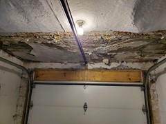 This is a garage ceiling showing extensive water damage due to leakage from above.