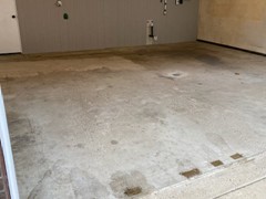 The original garage floor is spalling and cracking.  The floor is also uneven near the back wall.