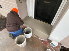 A front porch we power washed, did repairs, and resurfaced with a brown tint color.