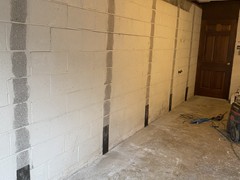 The wall was grinded where the straps will be installed, and the bottom anchors are installed.